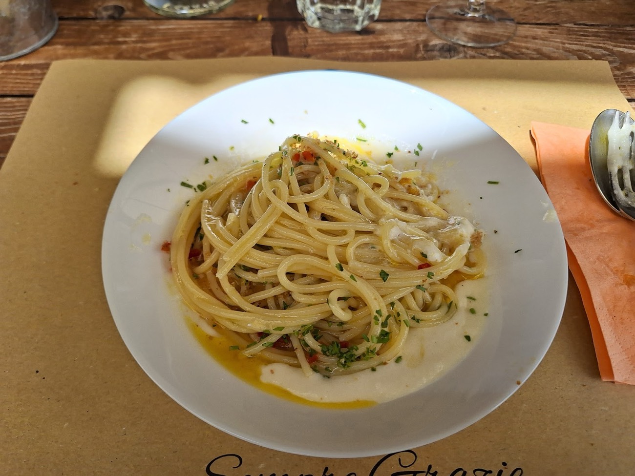 Un piatto di spaghetti servito su tavolo di legno all'aperto